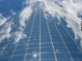 The curved glass facade reflects the sky.