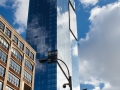 The tower reflects and contasts with surrounding masonry structures.